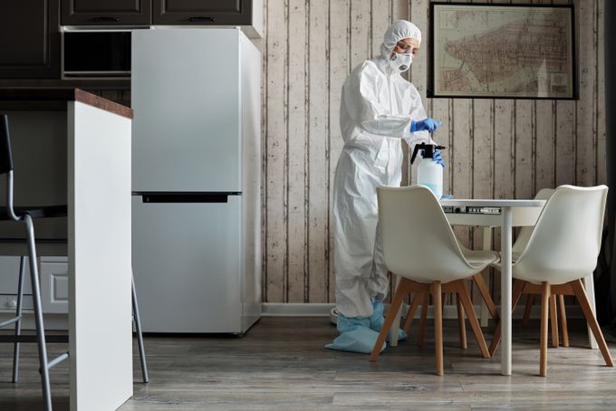 A cleaner treating a small apartment kitchen